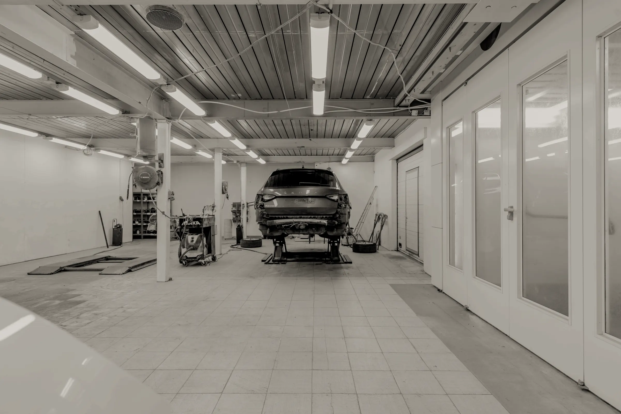 Werkstatt mit Fahrzeug auf der Hebebühne